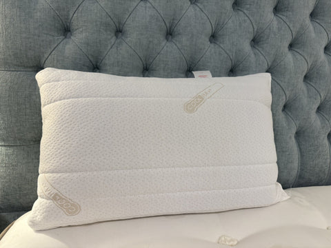 Gray pillow on a bed with tufted headboard